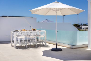 Güneşli havada, sandalyeli ve güneşli açık hava yemek masası..