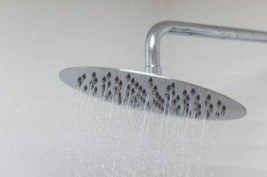 Modern duş başlığına yakın çekim ve aşağı su akışı.