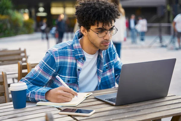 Young Pensive Man Freelancer Using Laptop Computer Taking Notes Watching — Stock Photo, Image