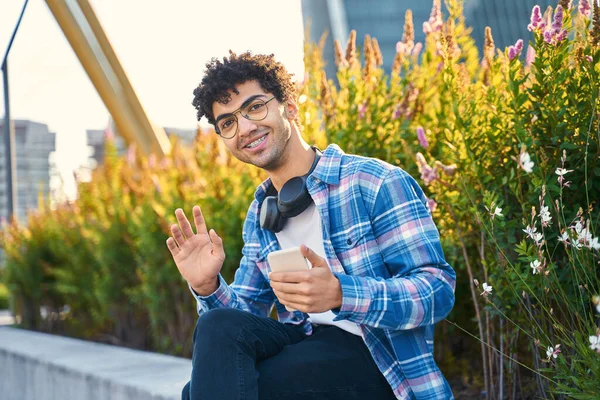 Bonito Sorrindo Estudante Oriente Médio Segurando Celular Acenando Mão Olhando — Fotografia de Stock
