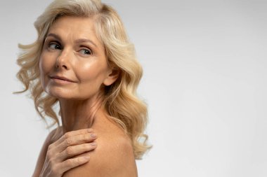 Kendine güvenen, kendine güvenen, şık dalgalı saçlı güzel bir kadının yakın plan portresi. Arka planda izole edilmiş, kopyalama alanı. Sağlıklı yaşam tarzı, doğal güzellik kavramı 