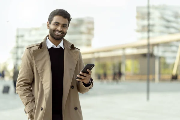 Посмішка Привабливого Індійського Чоловіка Який Тримає Мобільний Язок Онлайн Дивлячись — стокове фото