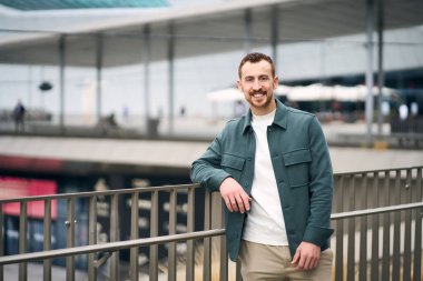 Kendine güvenen kızıl saçlı, şık giyinmiş, sokakta kameraya bakan bir adamın portresi. Pozitif yaşam tarzı 