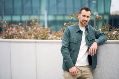 Gülümseyen kızıl saçlı şık giyinmiş genç adam sokaktaki kameraya bakıyor, mekanı kopyalıyor. 