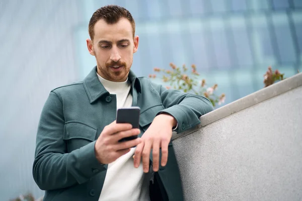 Привабливий Сучасний Чоловік Тримає Мобільний Телефон Читаючи Текстове Повідомлення Вулиці — стокове фото