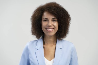 Close-up portrait confident ethnic young woman with afro hair, freelancer, entrepreneur, business person, office manager, smiling a beautiful toothy smile looking at camera, isolated blue background 