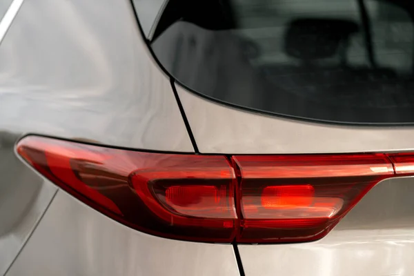 Details: Headlights - rear brake lights - of a modern comfortable car with a partial view of the rear bumper