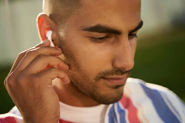 Sokaklarda Oturan Müzik Dinleyen Kablosuz Kulaklık Takan Genç Bir Orta — Stok fotoğraf