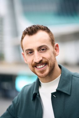 Portrait of smiling confident man posing to camera at business district