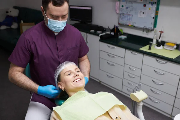 迷人的白人妇女在牙科诊所的预约 躺在牙医的椅子上 微笑着美丽的全副笑容 医疗保健和医药的概念 病人探访及卫生工作者 — 图库照片