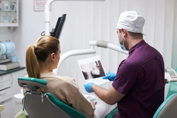 一个有爱心的男牙医的后视镜 向坐在牙医座位上的病人展示X光图像 技术和保健概念 牙科诊所 4K视频 — 图库照片
