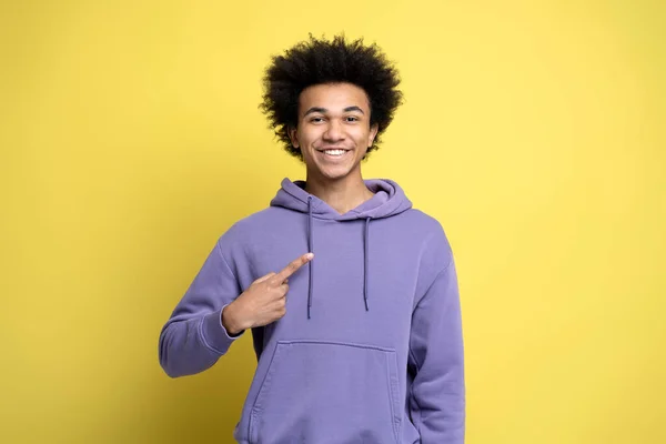 Young Smiling Curly Haired Man Wearing Stylish Purple Hoodie Pointing — Fotografia de Stock