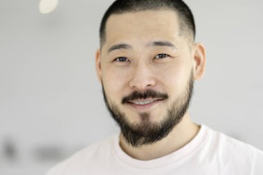 Closeup portrait of young smiling successful Asian man. Handsome model posing for pictures, looking at camera isolated on background 