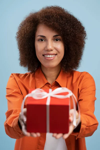 Satisfied Young Female Holding Out Red Wrapped Gift Box Giving — Stockfoto