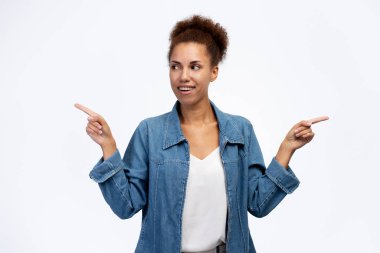 Portrait of smiling confident African American business woman looking away and pointing different sides isolated on white background. People concept