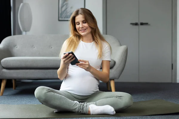Mujer Embarazada Sonriente Sosteniendo Teléfono Inteligente Usando Aplicación Móvil Viendo — Foto de Stock