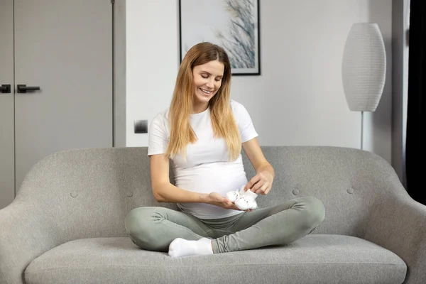 Ung Leende Gravid Kvinna Som Håller Små Baby Skor Förbereda — Stockfoto