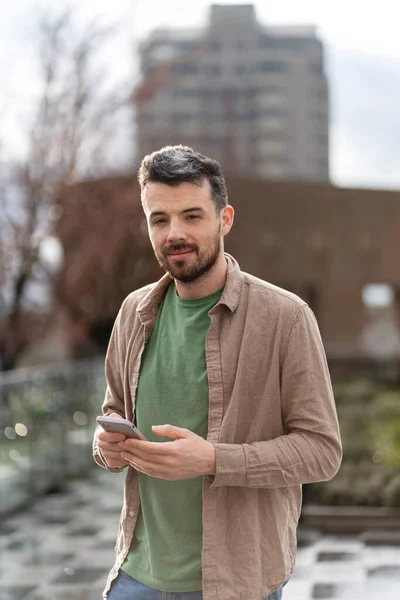 Lächelnder Hispanischer Mann Mit Handy Online Kommunikation Auf Der Straße — Stockfoto