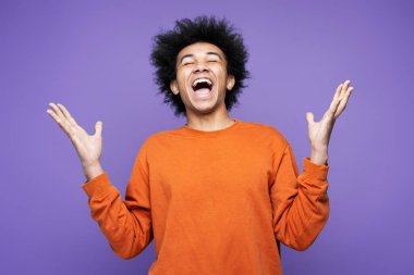 Mutlu Afrikalı Amerikalı adam çığlık atıyor, duygusal olarak seviniyor ve menekşe arka planda kendini çok mutlu hissediyor. İnsan duyguları kavramı 
