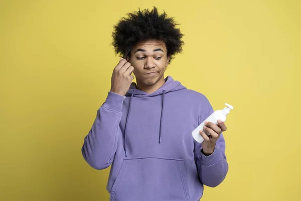 Pondering Curly Haired Multiracial Man Holding Bottle Hair Shampoo Looking — Stock Photo, Image