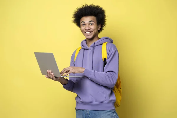 黄色の背景に隔離された高速インターネットを持つビデオを見て ラップトップコンピュータを使用して若いアフリカ系アメリカ人の男 笑顔の学生勉強 言語を学ぶ オンライン教育の概念 — ストック写真