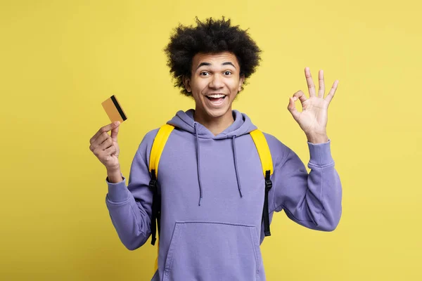魅力的な笑顔黄色の背景に隔離されたカメラを見てクレジットカードを保持アフリカ系アメリカ人男性 電子マネー ショッピング 販売の概念 — ストック写真