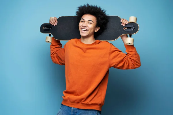 Young Smiling African American Man Holding Longboard Isolated Blue Background — Foto Stock