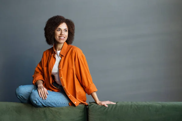 Portret Zachwycającej Zamyślonej Szczęśliwej Afroamerykanki Marzącej Odwracaniu Wzroku Siedzącej Kanapie — Zdjęcie stockowe