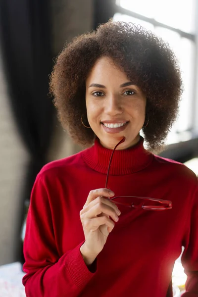 穿着休闲装的非洲裔美籍美女 戴着时髦的红色镜框眼镜 带着美丽的笑容 自信地看着相机 成功人民的概念 — 图库照片
