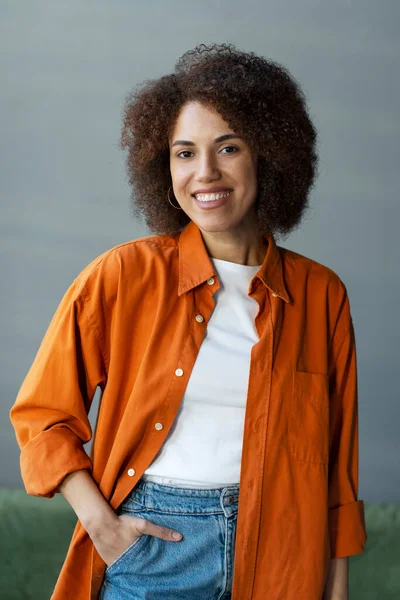 Portret Uśmiechniętej Pewnej Siebie Afroamerykanki Stylowej Pomarańczowej Koszulce Stojącej Domu — Zdjęcie stockowe
