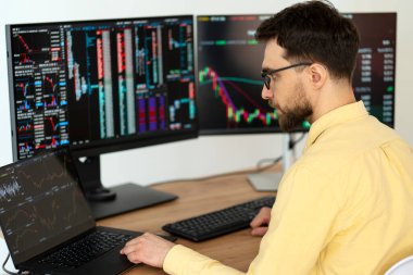 Modern ofiste kripto çizelgesiyle çalışan, dizüstü bilgisayar kullanan yakışıklı bir tüccar. Borsa araştırmacısı. Başarılı iş, çevrimiçi ticaret kavramı