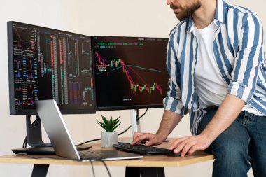 Şifreli çizelgeyle çalışan ciddi bir tüccar modern ve seçici bir odak noktasında oturuyor. Çevrimiçi ticaret