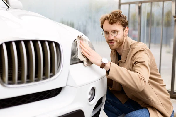 Sluiten Van Glimlachende Aantrekkelijke Man Vegen Koplampen Van Auto Met — Stockfoto