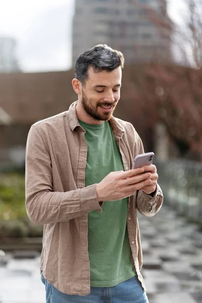 Usmívající Pohledný Latinský Muž Držící Mobilní Telefon Čtoucí Sms Ulici — Stock fotografie