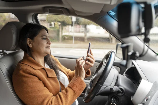 Portrait Busy Mature Indian Woman Holding Mobile Phone Driving Car — Stock Photo, Image