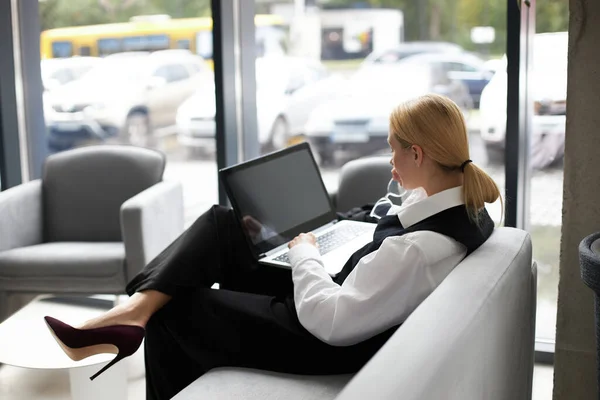 stock image Businesswoman using laptop computer, typing, working online, looking at laptop screen in modern office. Freelancer copywriter sitting at workplace