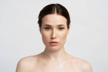  Genç, kendine güvenen bir kadın beyaz arka planda, duştan sonra aynaya bakıyor. Güzellik, sabah rutini konsepti