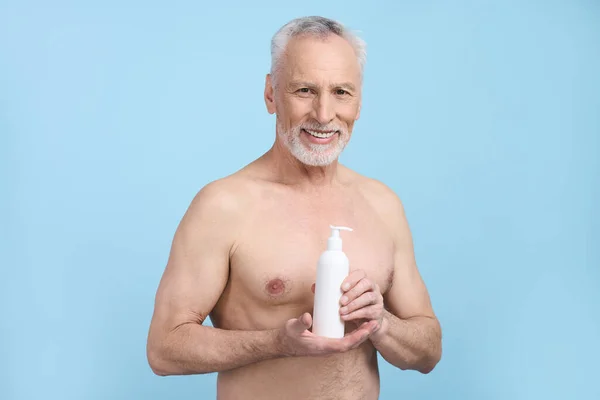 Beyaz Beyaz Bir Adam Elinde Nemlendirici Vücut Losyonuyla Beyaz Bir — Stok fotoğraf