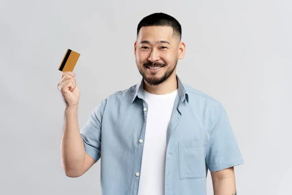 面带微笑的亚洲男人的画像 手里拿着银行票据 背景灰蒙蒙 电子货币的概念 — 图库照片