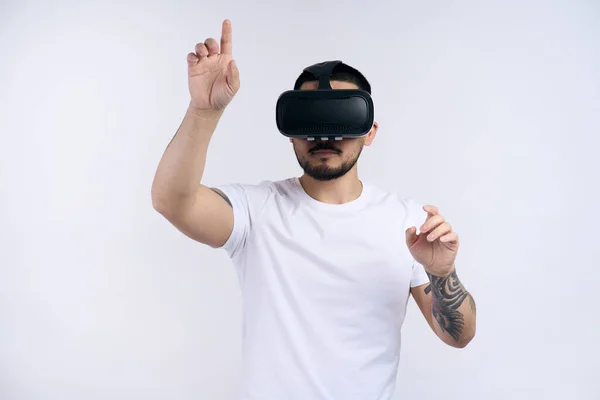 stock image Portrait of young man in white t shirt wearing vr goggles experiencing virtual reality using 3d headset. Technology, science, innovation and cyberspace concept 