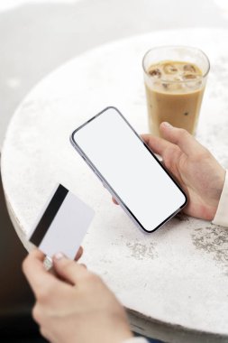 Akıllı telefon kullanan, kredi kartı alışverişi yapan, seçici odaklı bir kadın. Modelleme. Teknoloji konsepti 