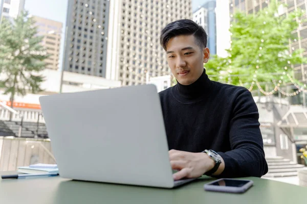 Handsome asian man, computer programmer using laptop working online sitting in at workplace. Young successful Chinese businessman planning project, checking email, watching training courses