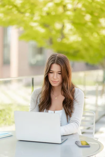 吸引人的可爱女人的肖像坐在工作场所 使用笔记本电脑 在网上工作 在街上 漂亮的经理看着屏幕和打字 技术概念 成功的商业 — 图库照片