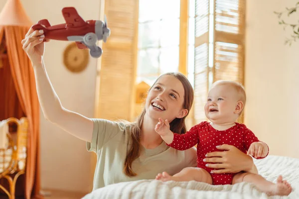 Junge Glückliche Babysitter Spielen Flugzeug Mit Niedlichen Kleinen Baby Sitzt — Stockfoto
