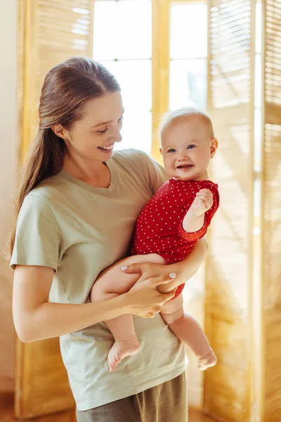 Joven Madre Positiva Sosteniendo Pequeño Hermoso Bebé Lindo Apartamento Casa —  Fotos de Stock
