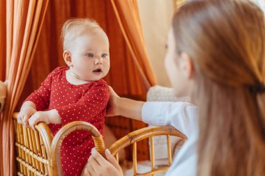 Çocuk parkında duran, oynayan, yanında oturan tatlı bir bebek. Sevimli bebeğe bakan güzel bir dadı. Sevgi, ilgi, ebeveynlik kavramı