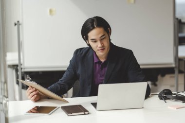 Çekici Asyalı iş adamının portresi, iş yerinde çalışmak, dizüstü bilgisayar kullanmak. Yakışıklı Japon İnsan Kaynakları müdürü özgeçmişine bakıyor. İş konsepti