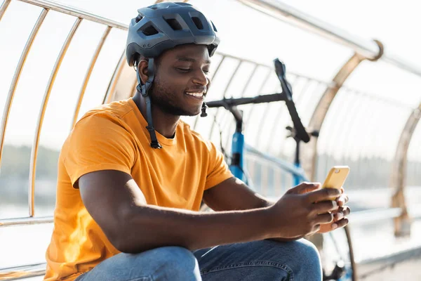 Przystojny Afroamerykanin Kasku Trzymający Telefon Komórkowy Robiący Zakupy Online Pobliżu — Zdjęcie stockowe