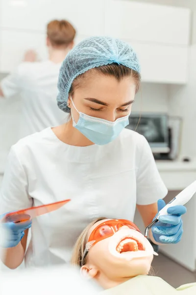 Dentista Femenina Uniforme Protector Haciendo Relleno Para Mujer Paciente Clínica —  Fotos de Stock