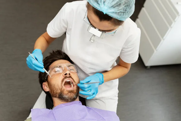 Dentiste Examinant Homme Barbu Patient Dans Clinique Dentaire Moderne Traitement — Photo